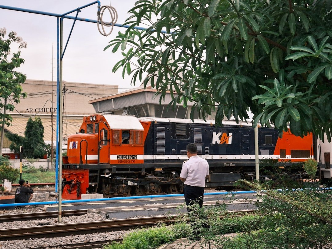 A man standing on a train track next to a train