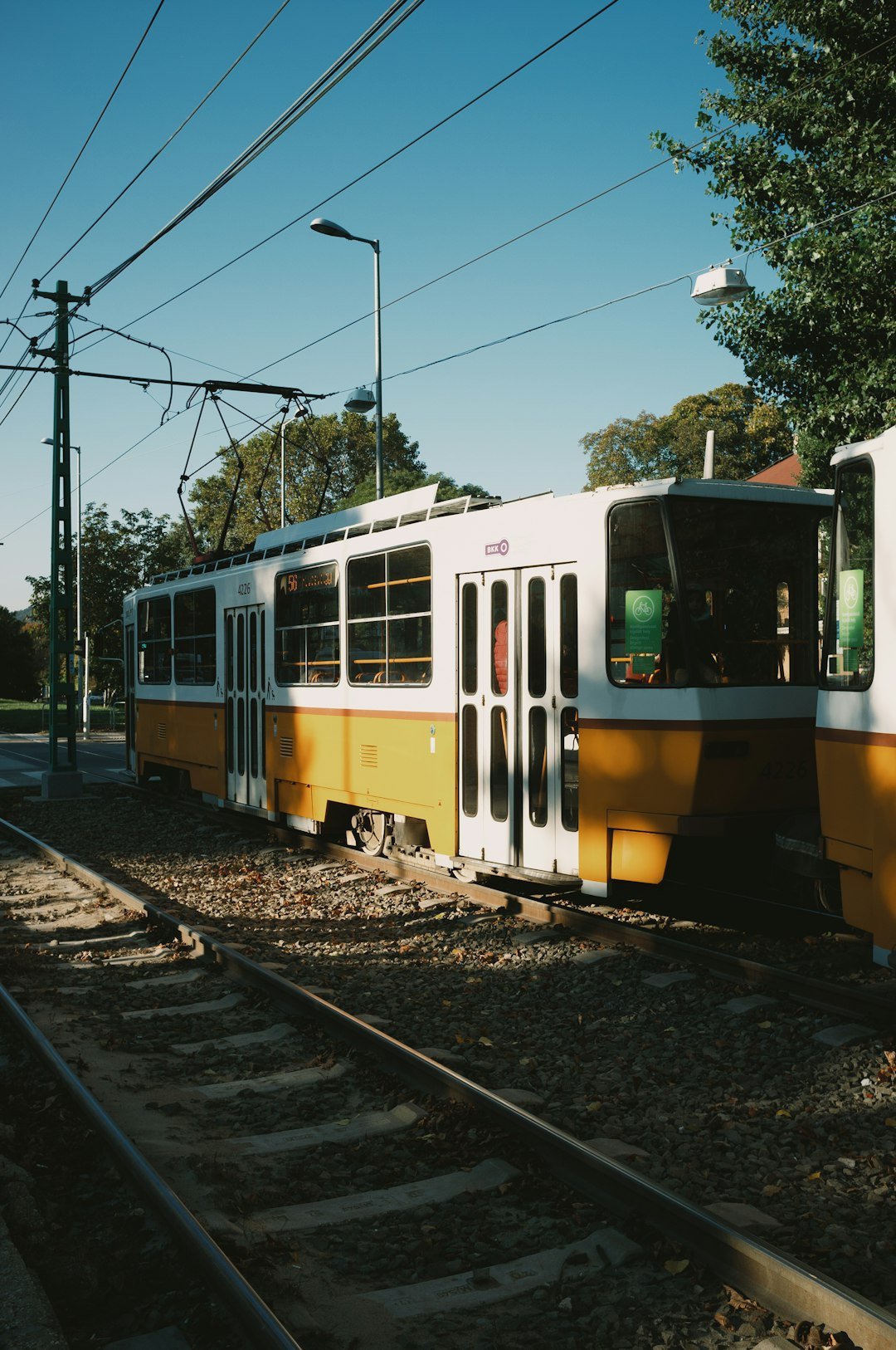 a yellow and white train traveling down train tracks