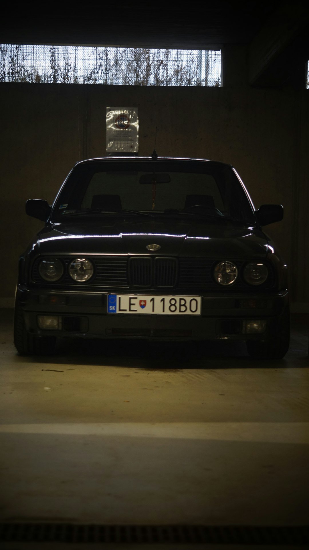 A black car parked in a parking garage