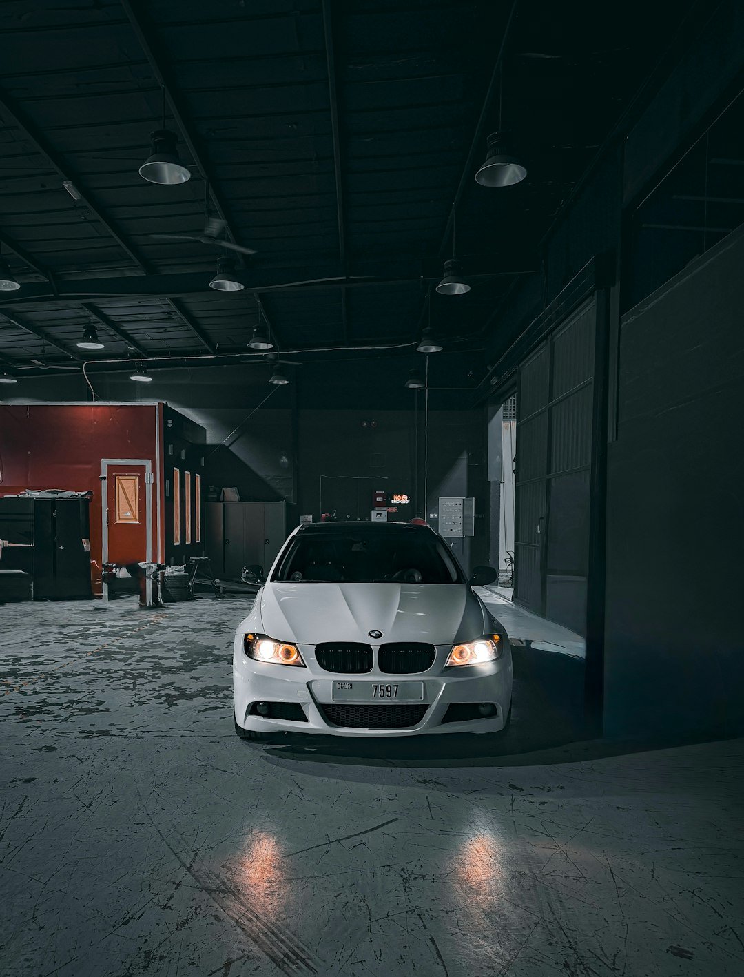 A white car is parked in a garage