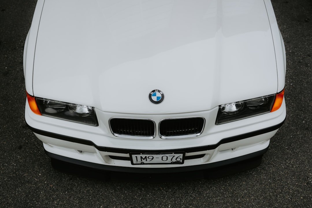 A white BMW car's front is shown.