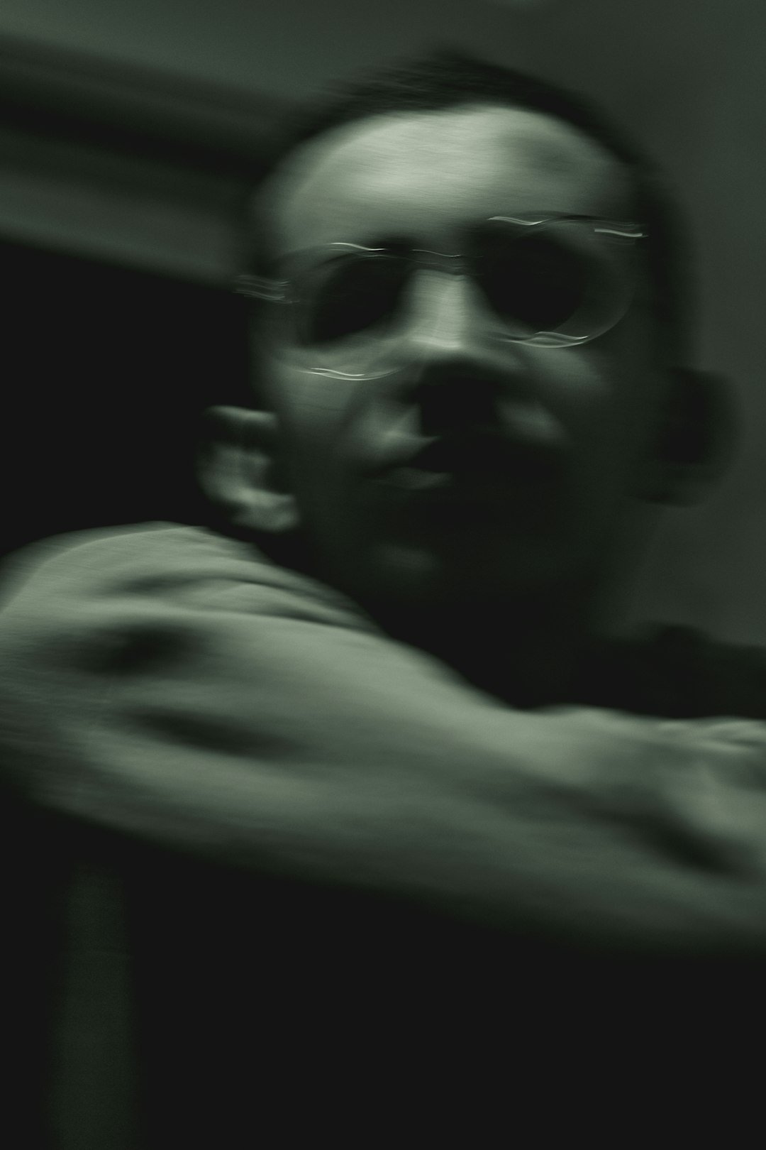 a man with glasses is holding a cell phone
