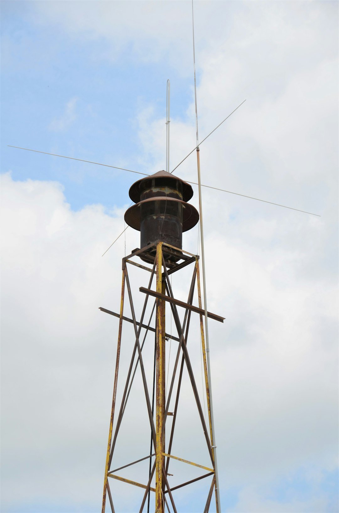 black and brown metal tower under white clouds