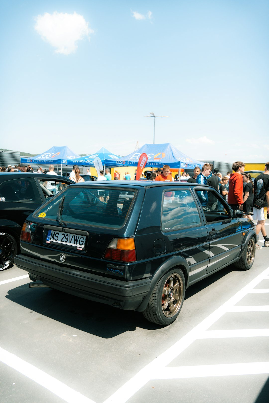 a small black car parked in a parking lot