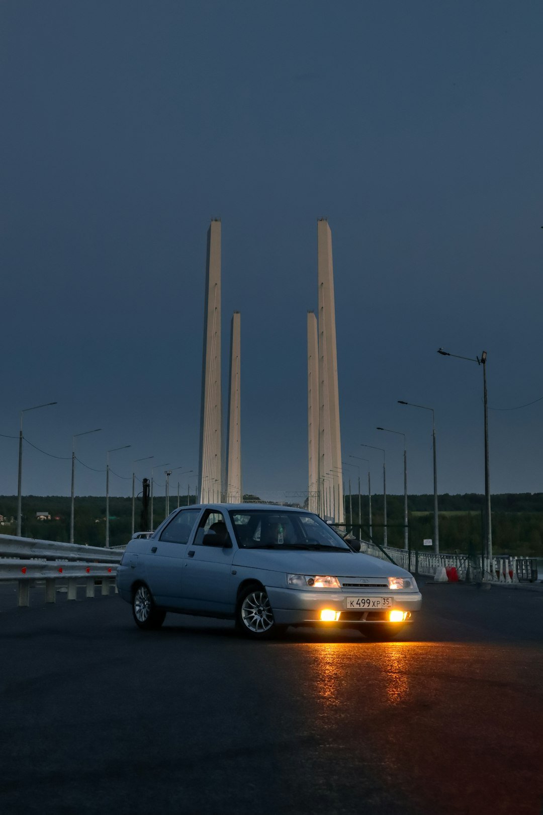 a car driving on a road with tall pillars in the background