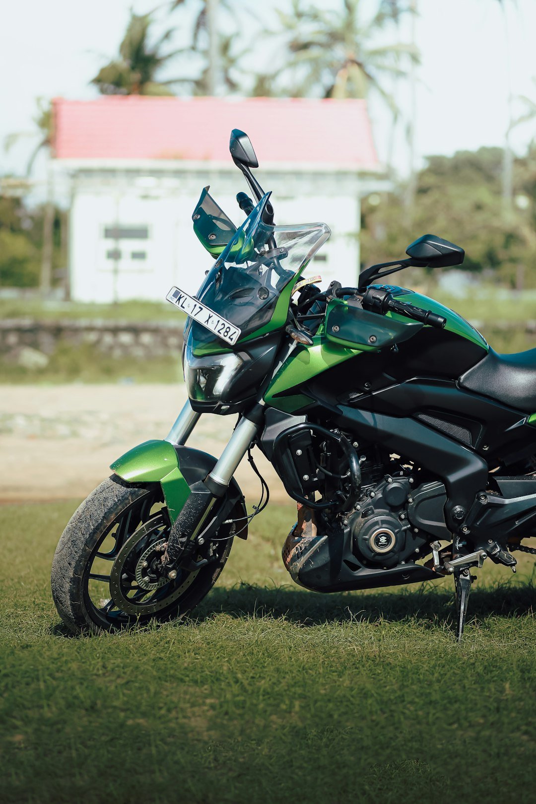 A green and black motorcycle parked in the grass