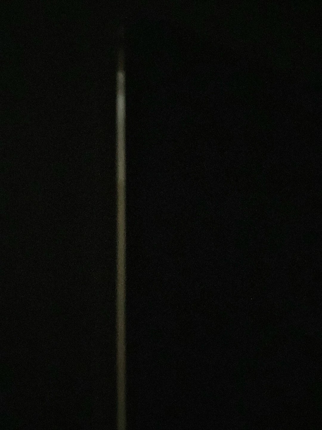 a black and white photo of a street light in the dark