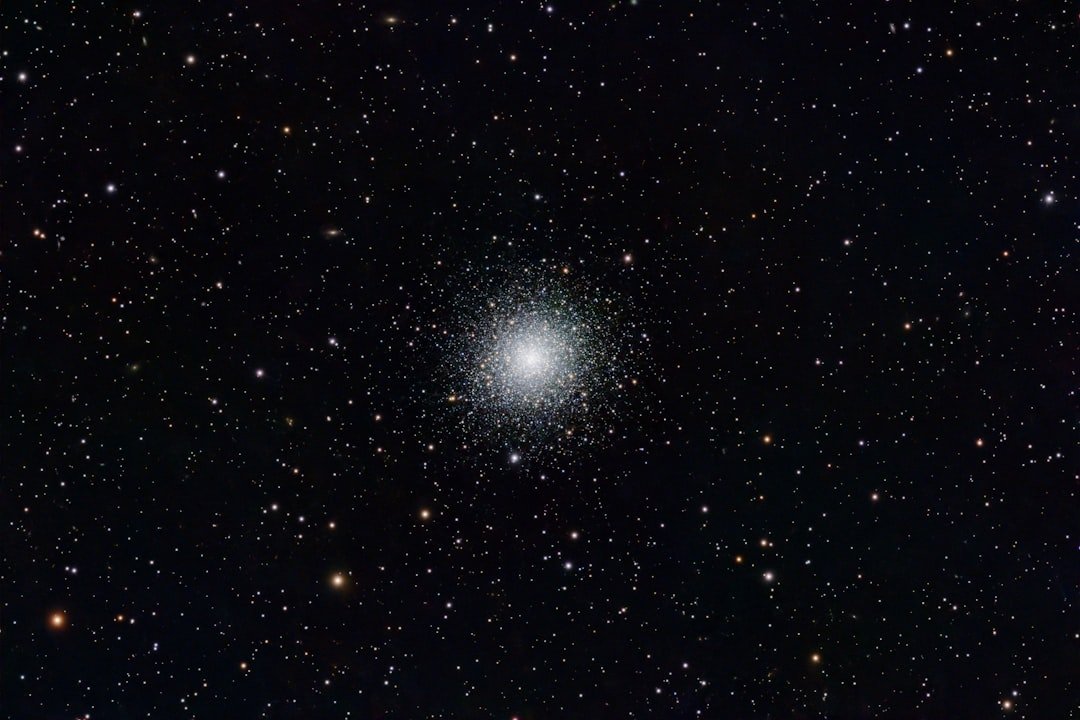 A globular cluster shines brightly against the stars.