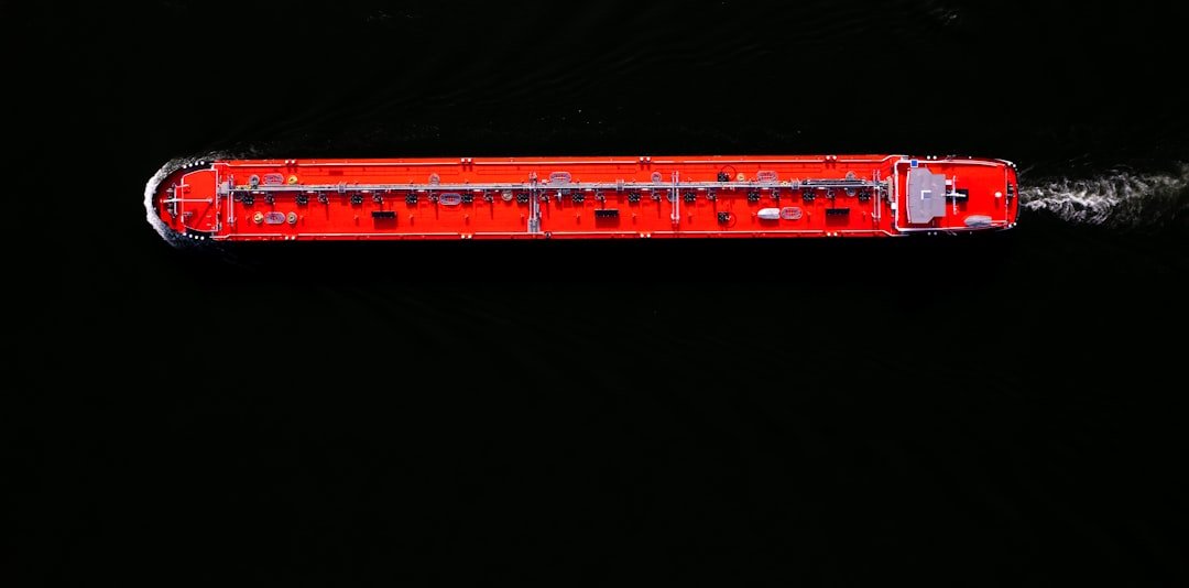 a red boat floating on top of a body of water