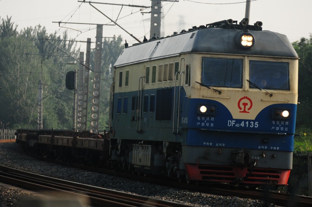 a blue and white train traveling down train tracks