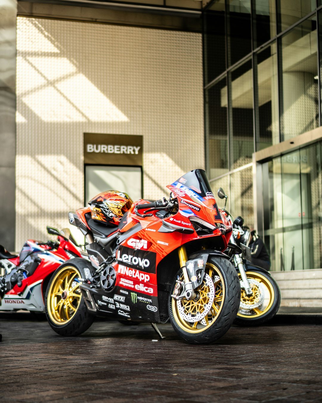 Two motorcycles parked next to each other in front of a building
