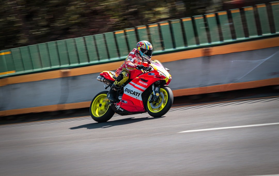 a man riding a red motorcycle down a curvy road