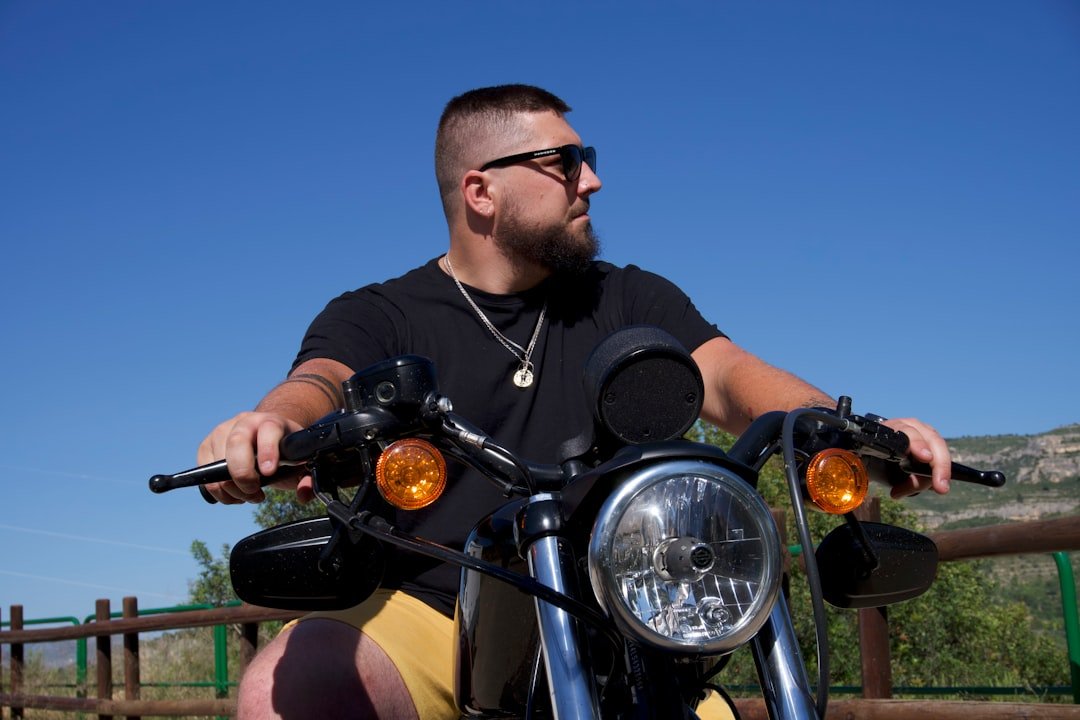 a man sitting on a motorcycle wearing sunglasses