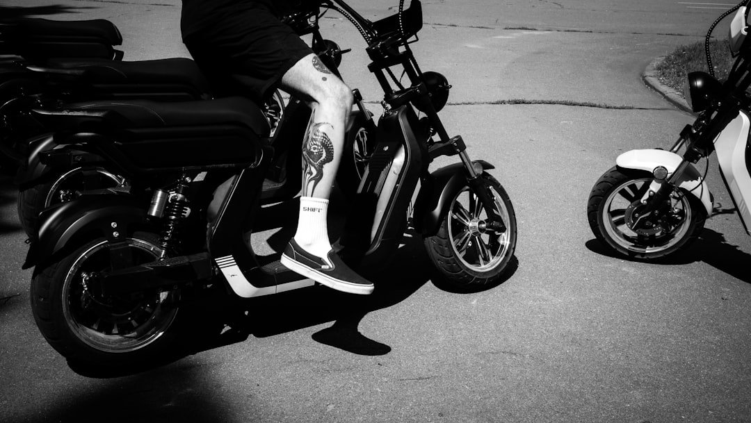 a man sitting on a scooter next to another scooter