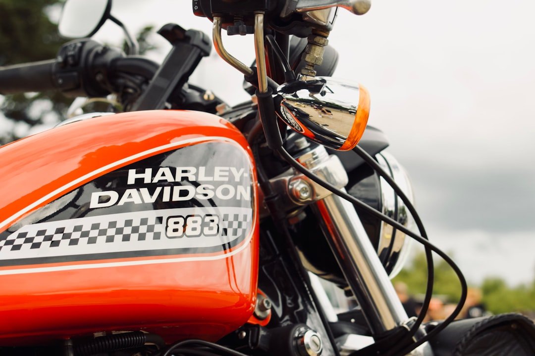 A close up of an orange motorcycle parked on a street
