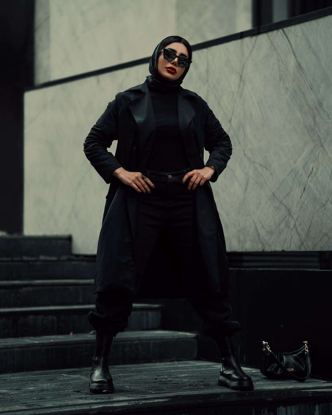 a woman in a black outfit standing on steps