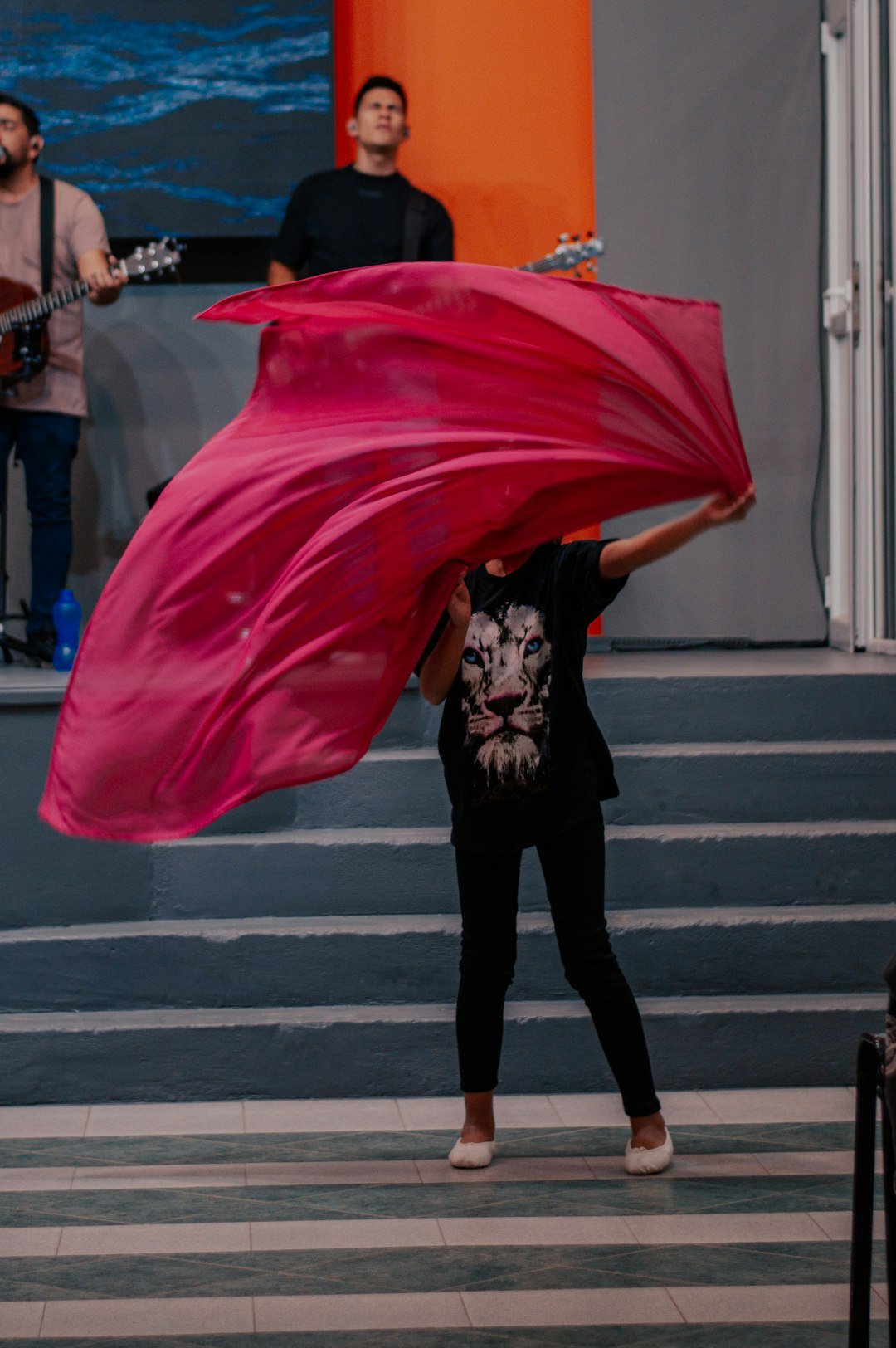 a woman is holding a pink cloth over her head