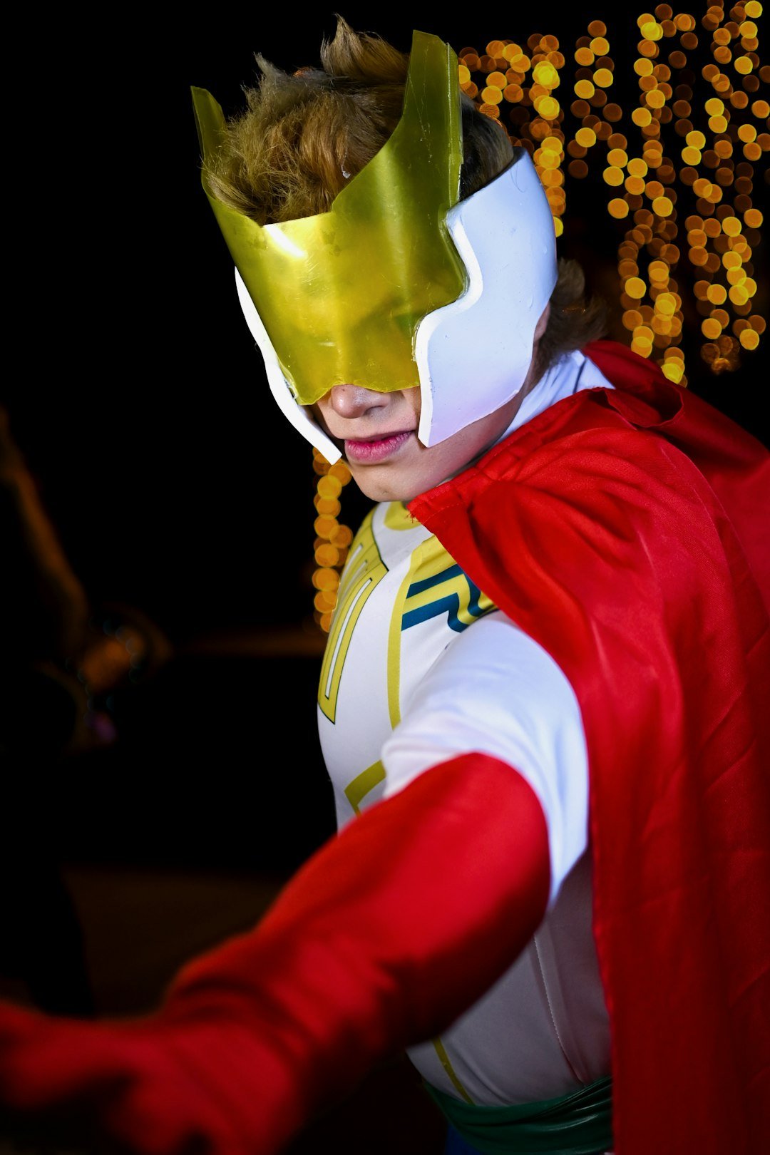a young boy dressed in a costume and cape