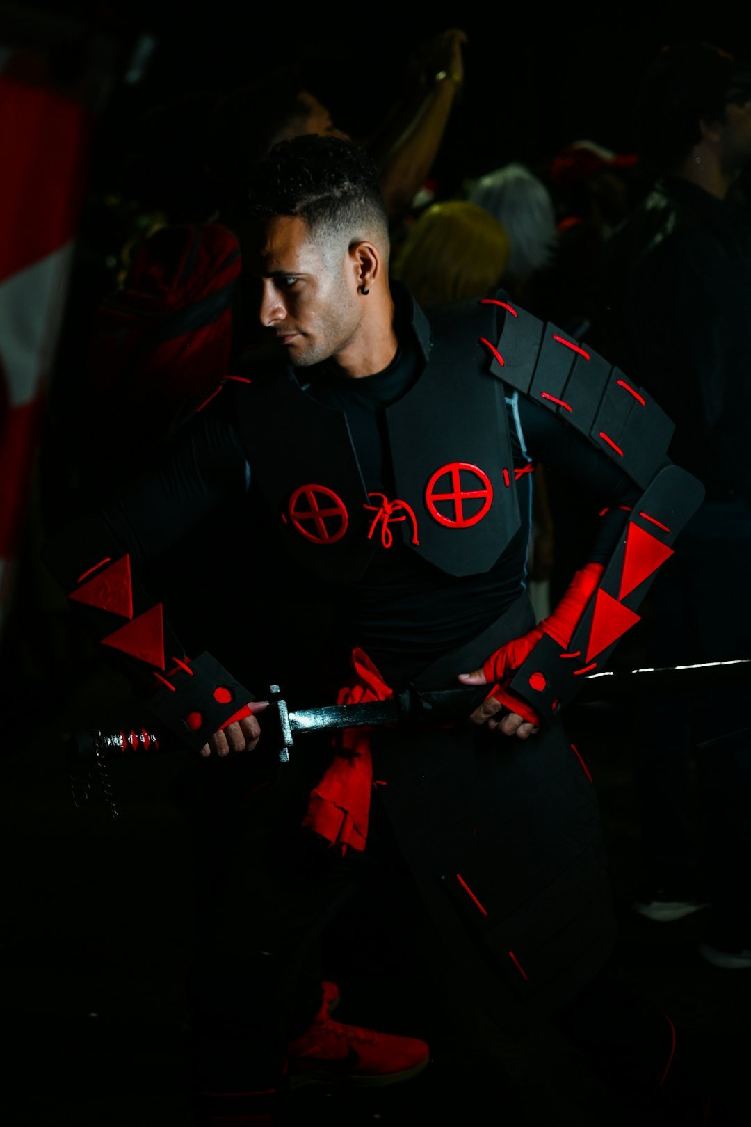 A man in a black and red outfit holding a sword