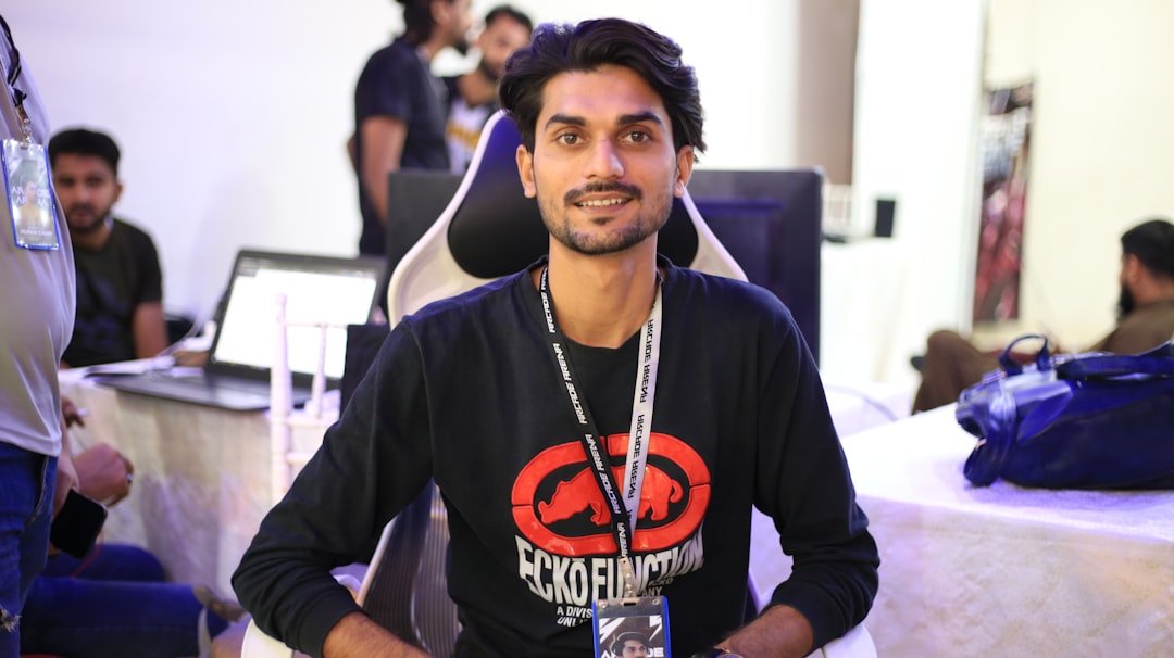 a man standing in front of a table with a laptop on it