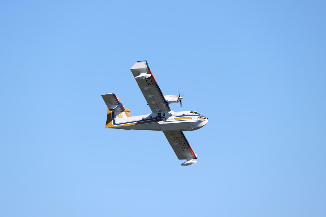 A small airplane flying through a blue sky