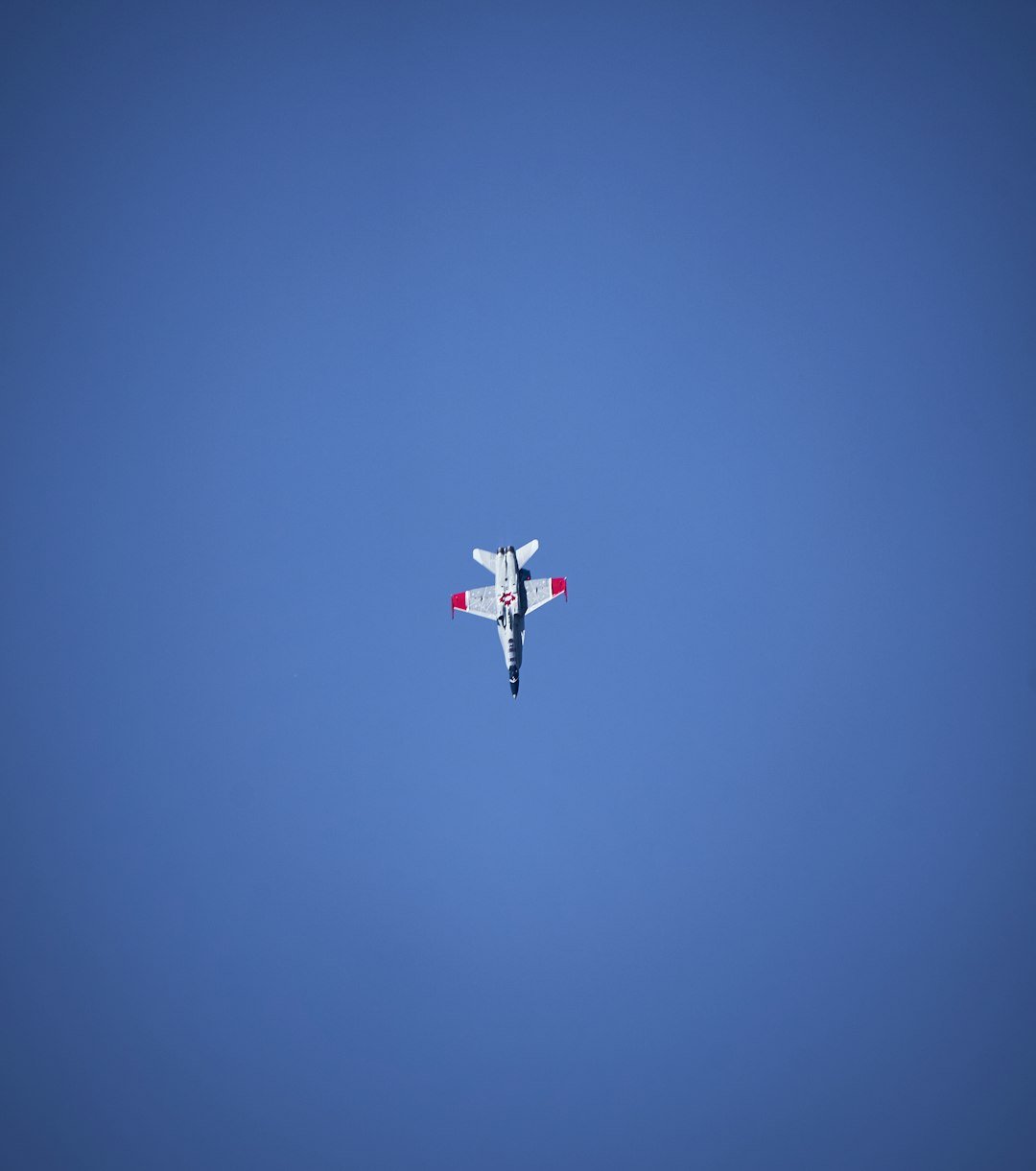 An airplane is flying in the blue sky