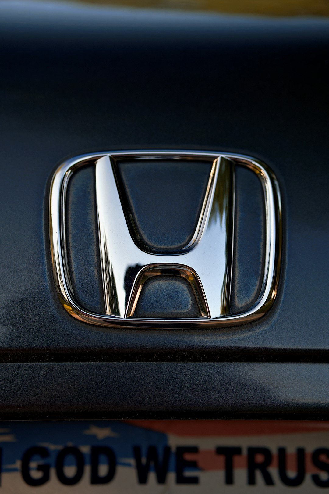 A shiny honda logo is displayed on a car.