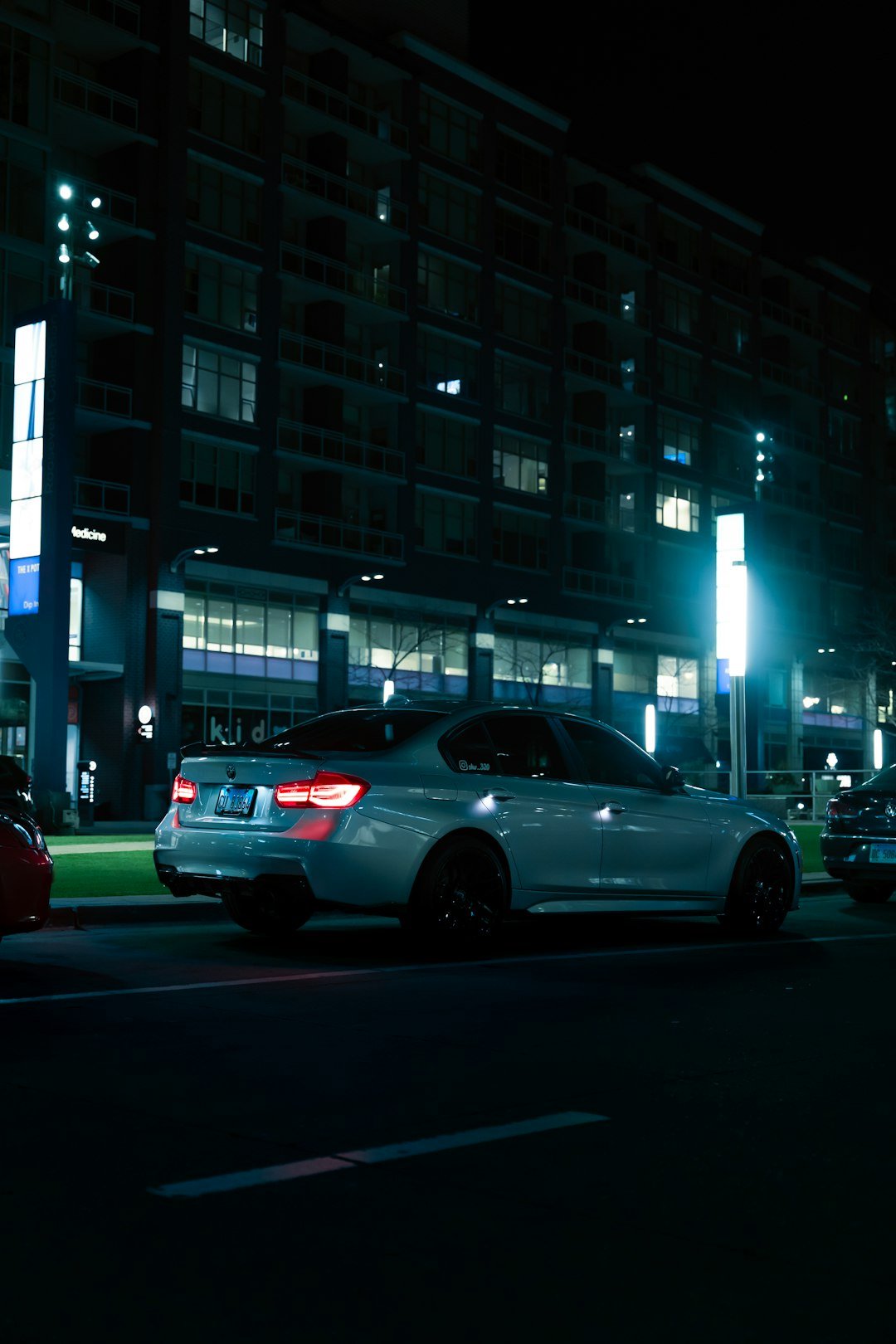a white car parked on the side of a road at night