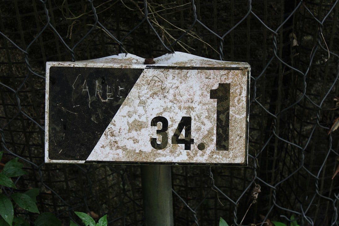 a sign that is on a pole in front of a fence