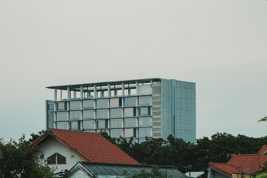 a tall building with a red roof next to trees