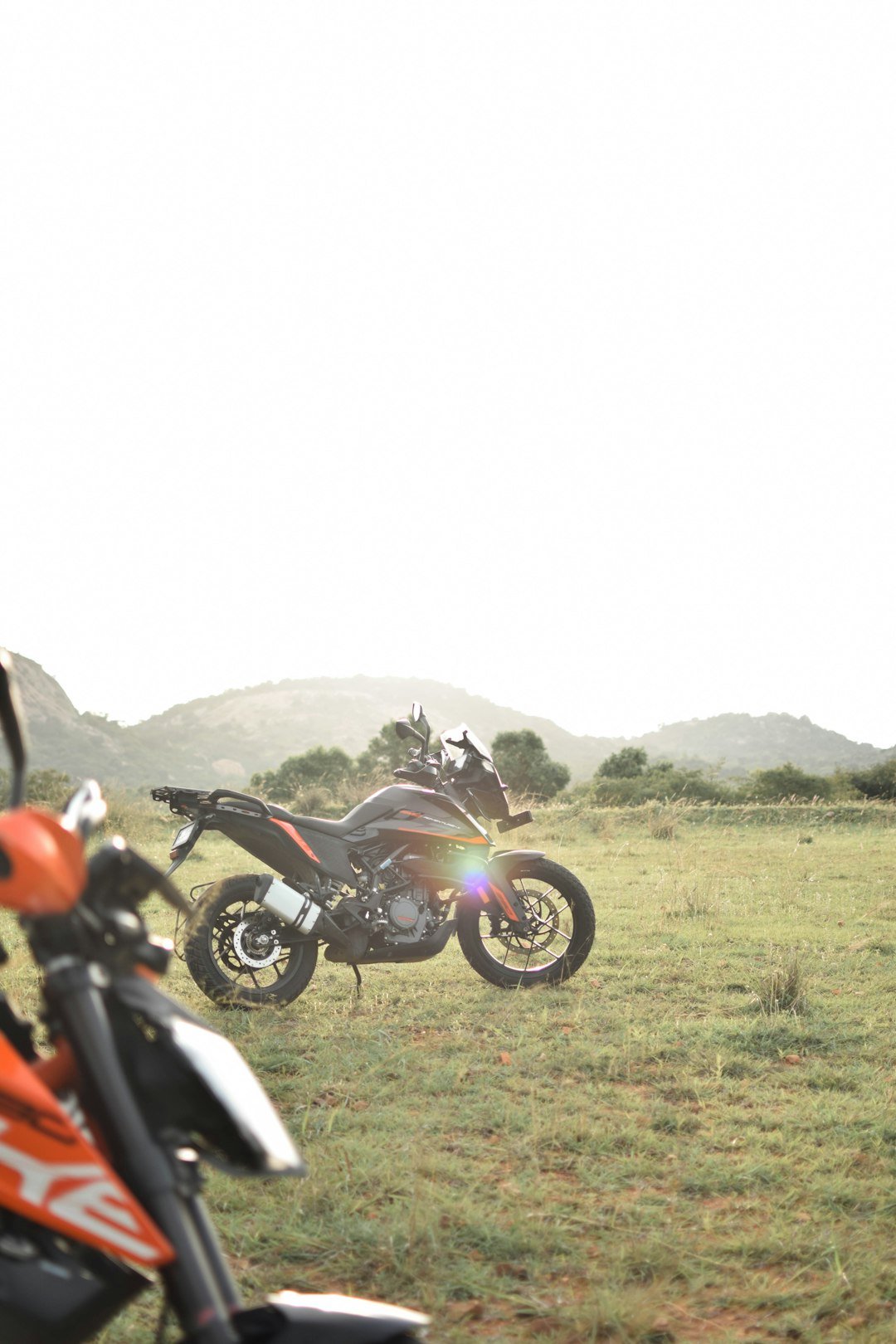 A couple of motorcycles parked in a field