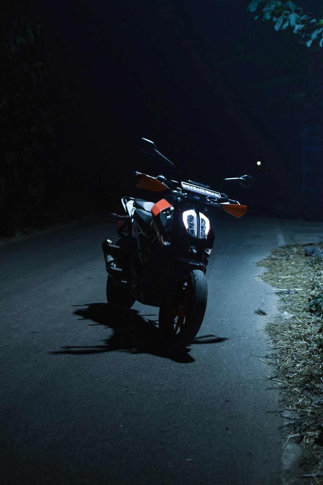 A motorcycle parked on the side of a road at night
