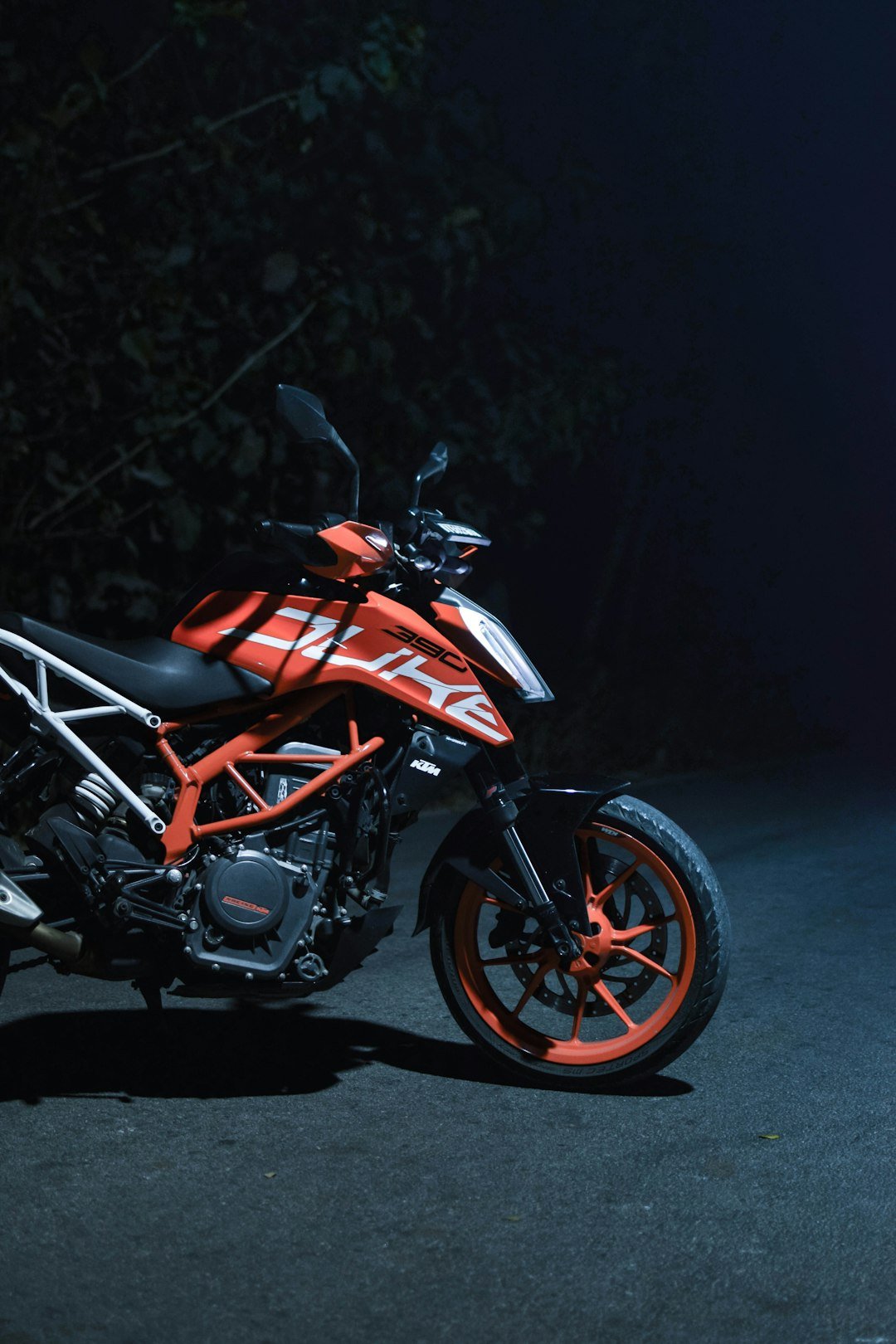 A red and black motorcycle parked in the dark