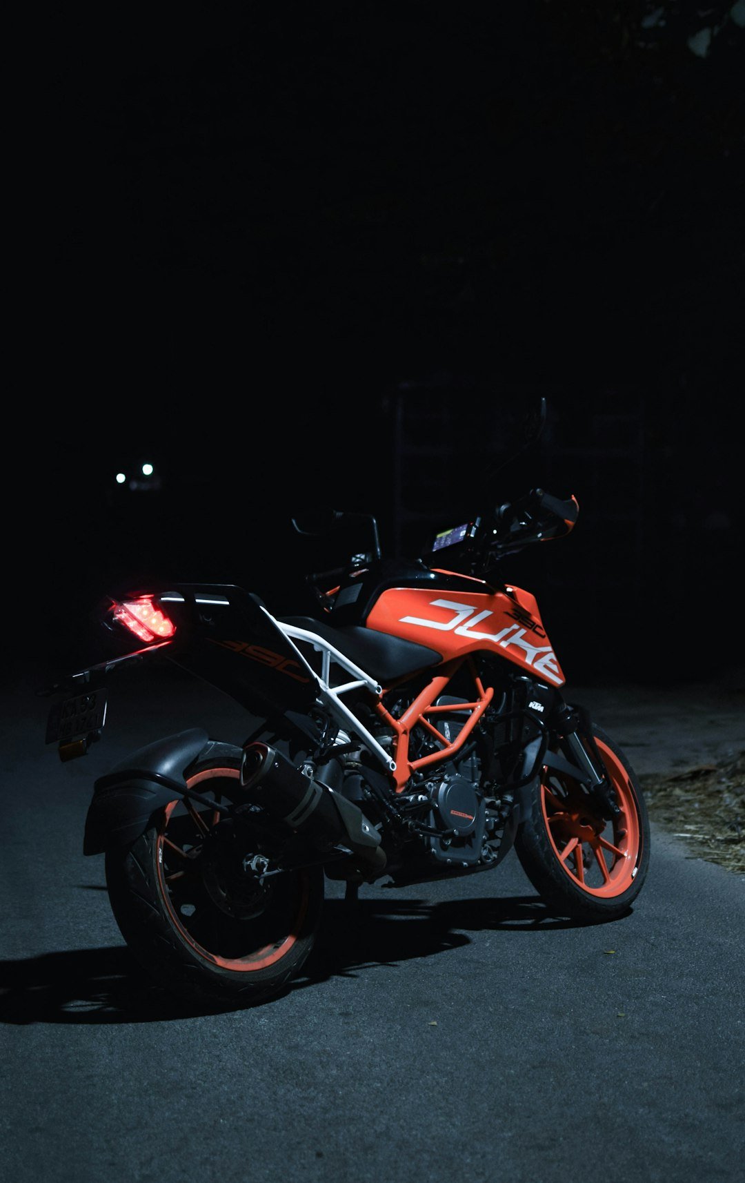 A motorcycle parked on the side of a road at night