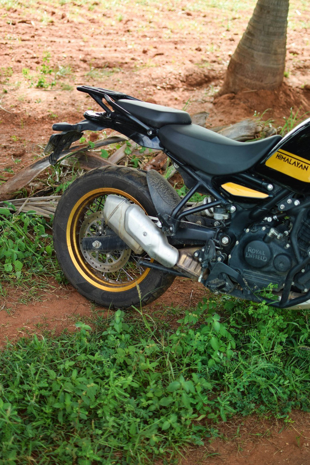 A motorcycle parked on the side of a dirt road