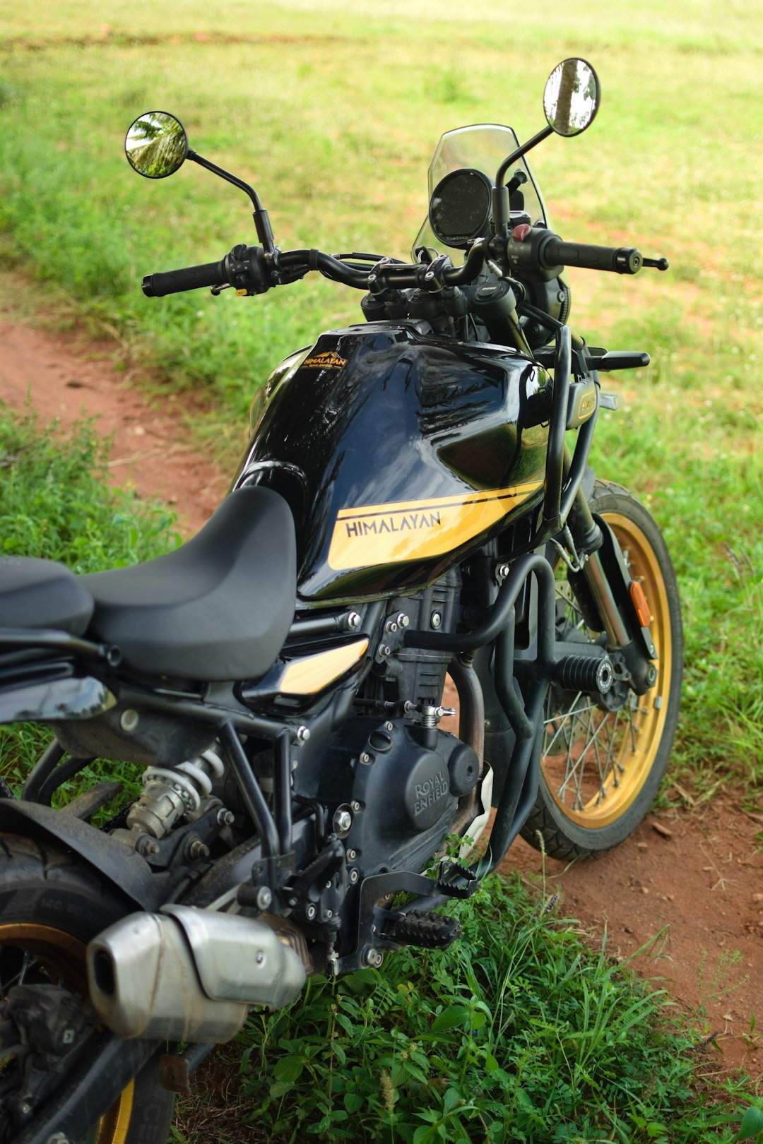 A motorcycle parked on the side of a dirt road