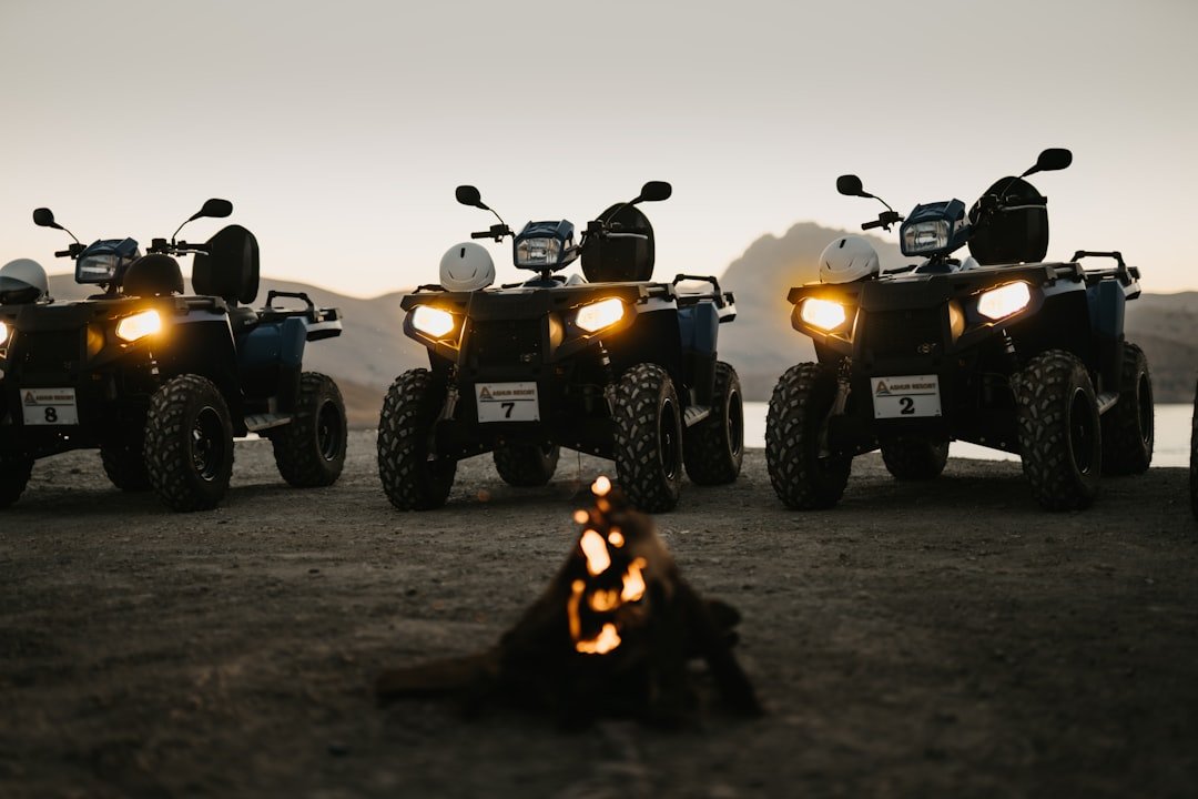 silhouette of 2 people riding atv during sunset