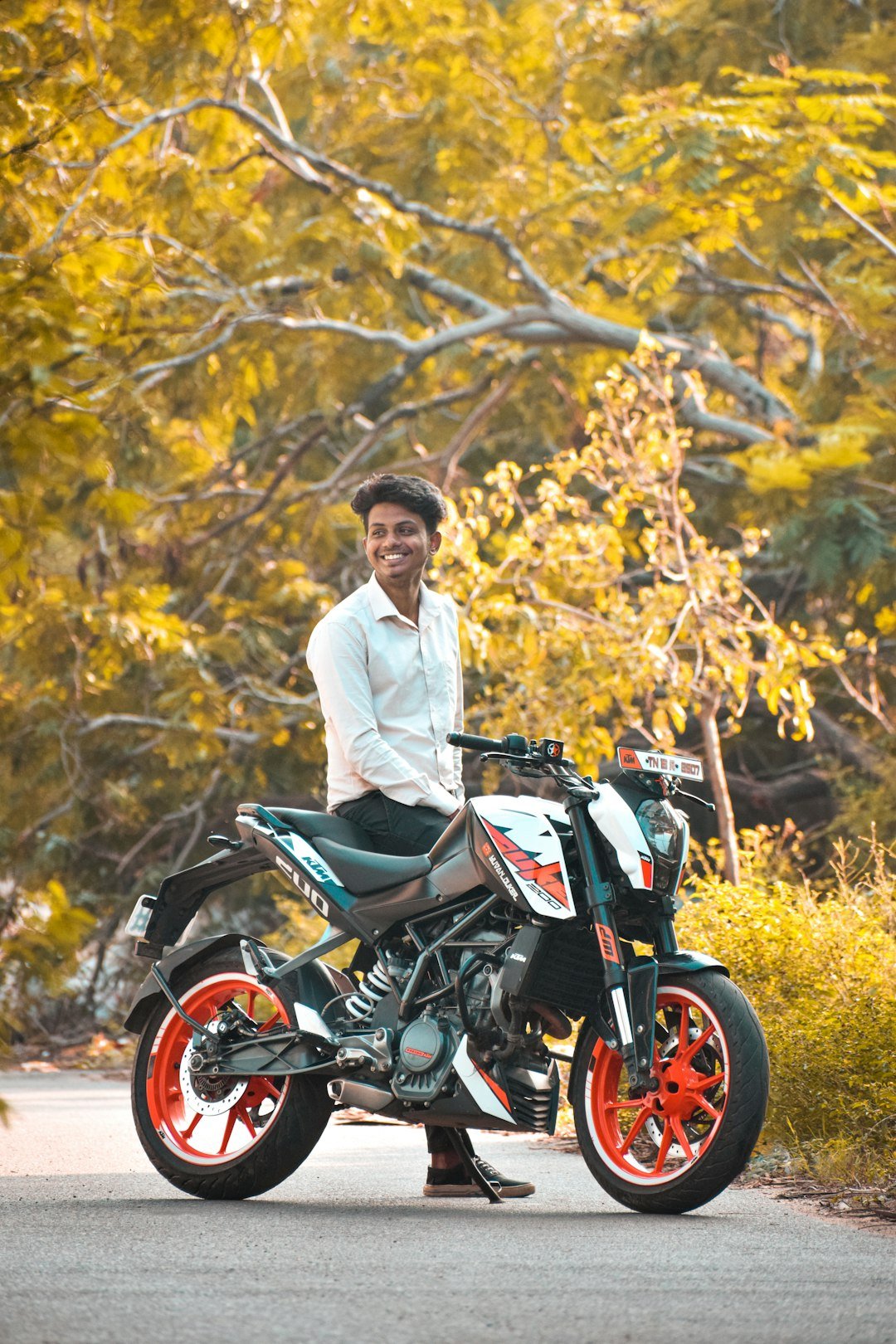 man in white dress shirt riding on black and red motorcycle
