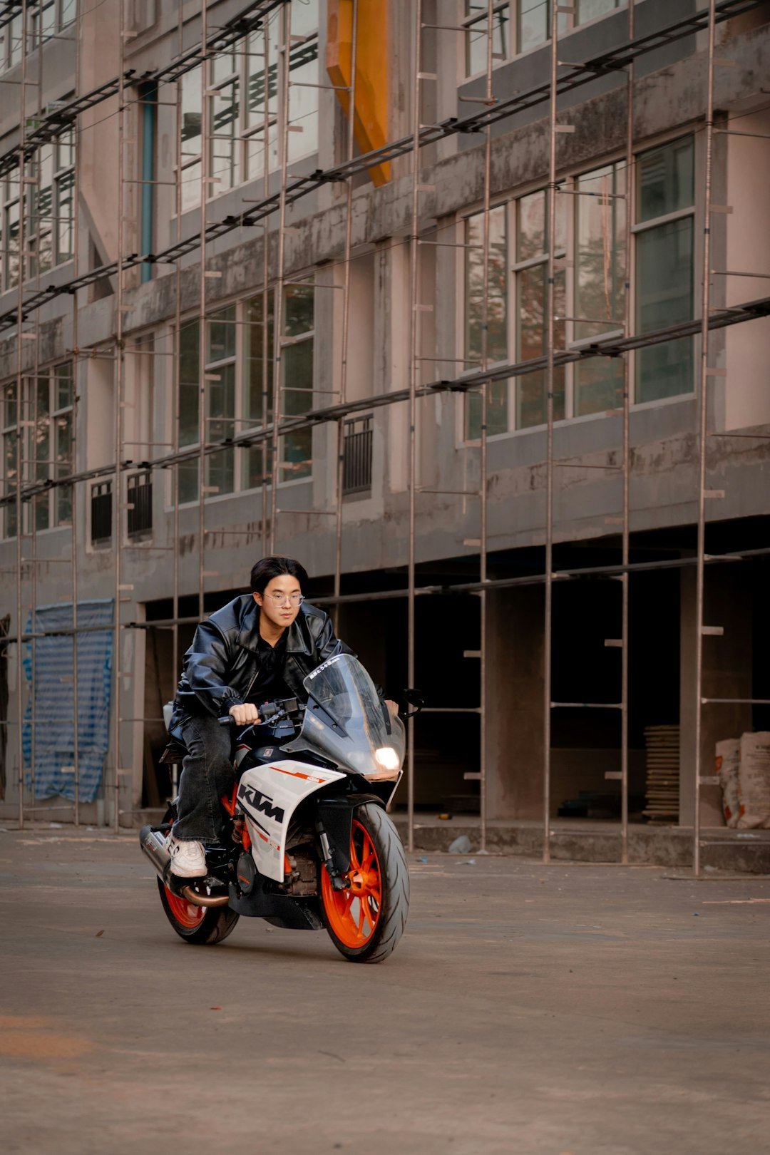 Man riding a motorcycle in front of a building.