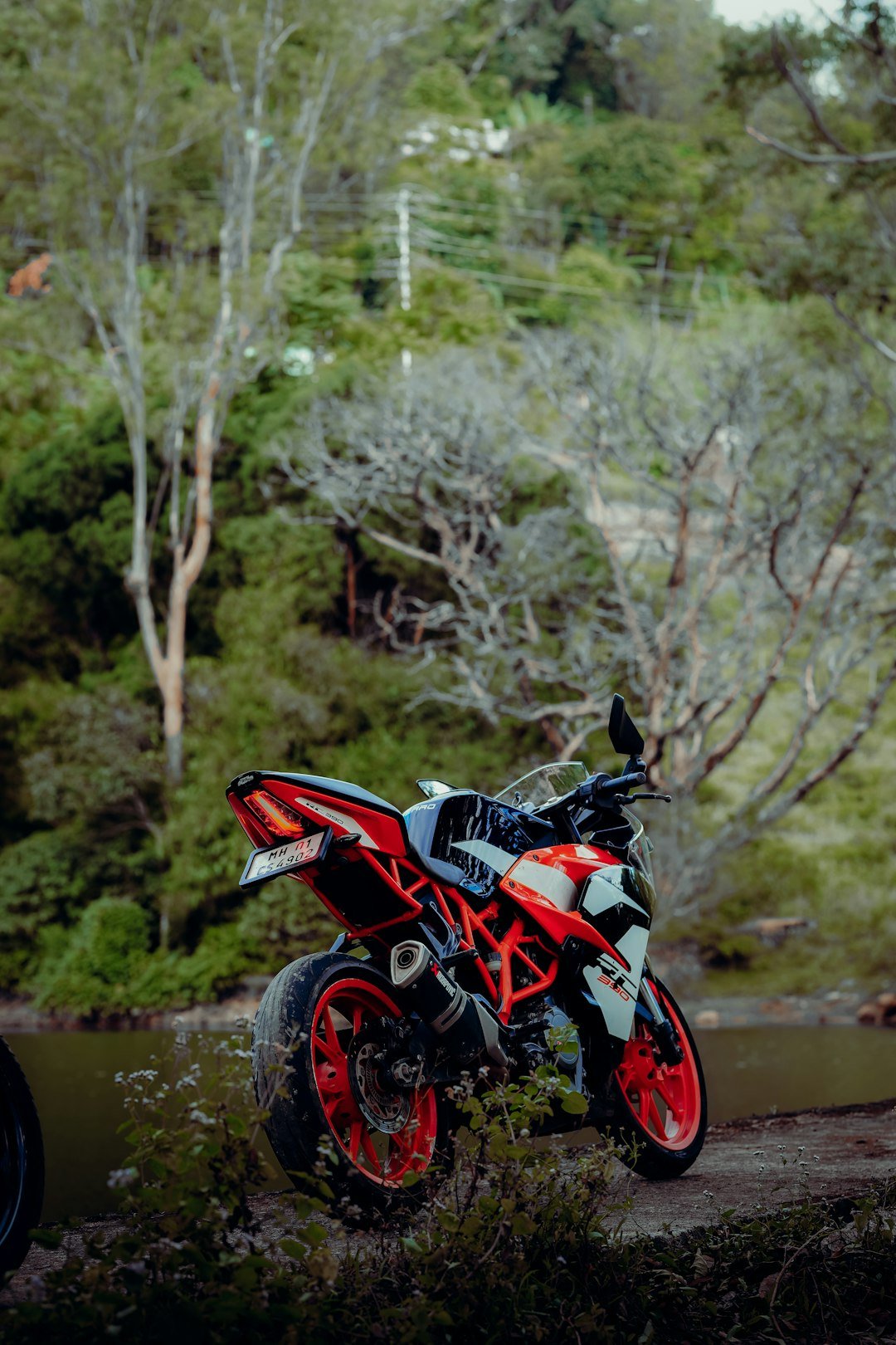 a red and black motorcycle parked on a dirt road