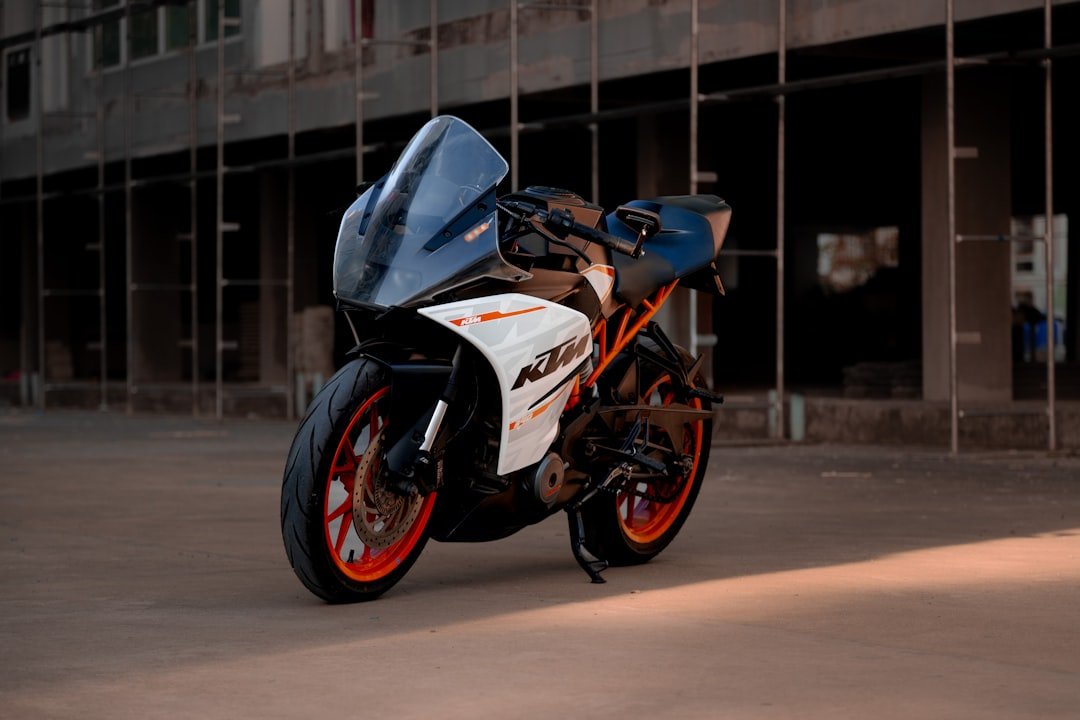 Here's a caption for the image: sporty ktm motorcycle parked outdoors on a concrete surface.