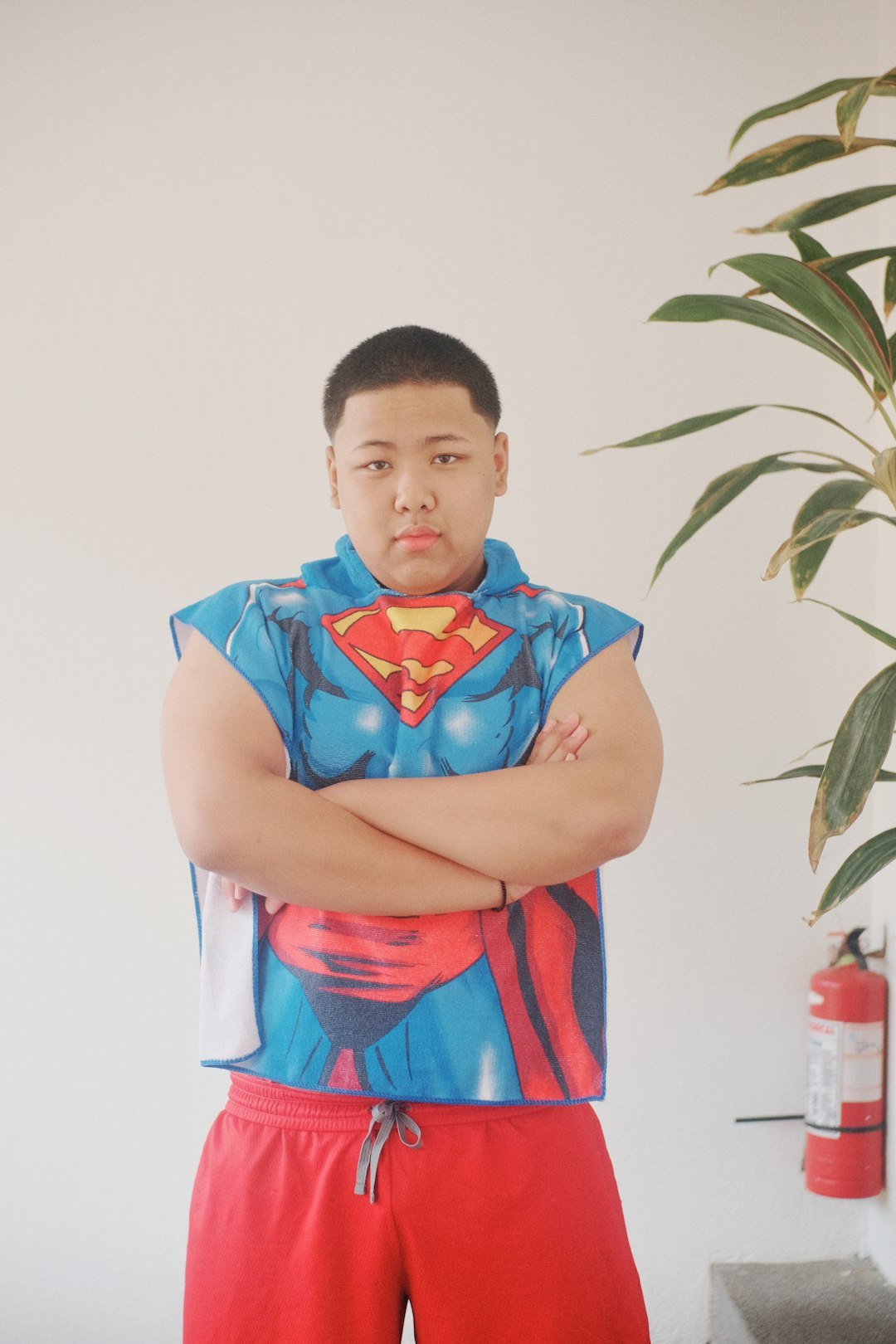 A man in a superman costume standing with his arms crossed