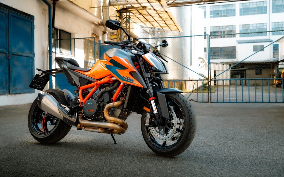an orange and black motorcycle parked in front of a building
