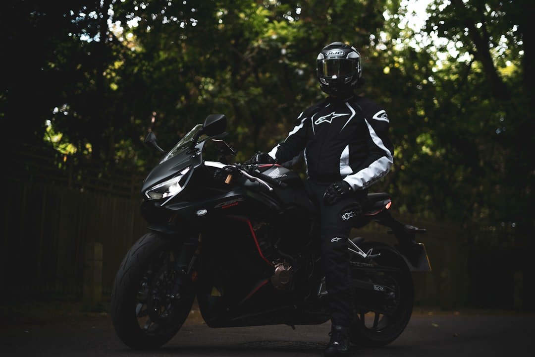 man in black and white motorcycle suit riding motorcycle