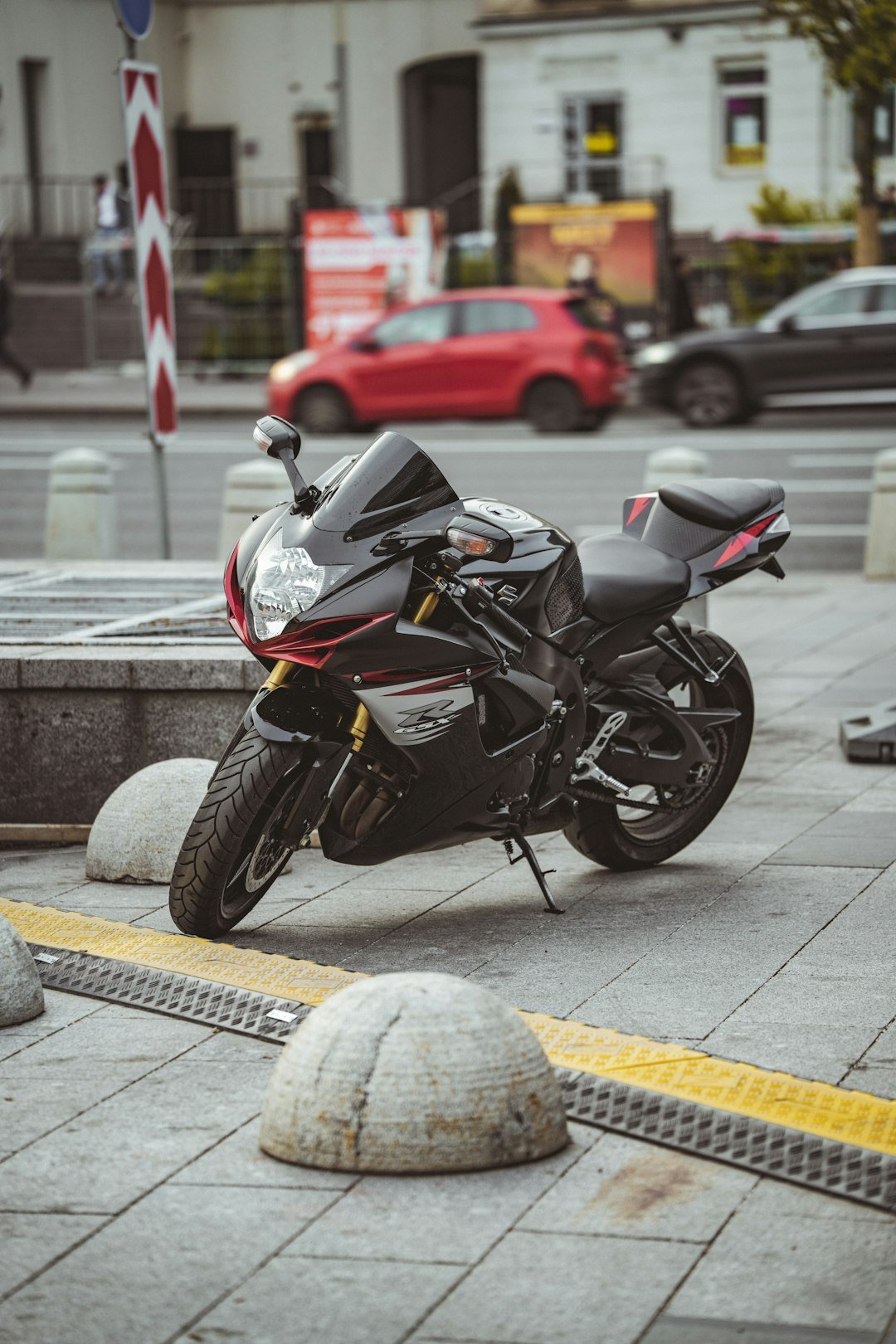 A black motorcycle is parked on the sidewalk.
