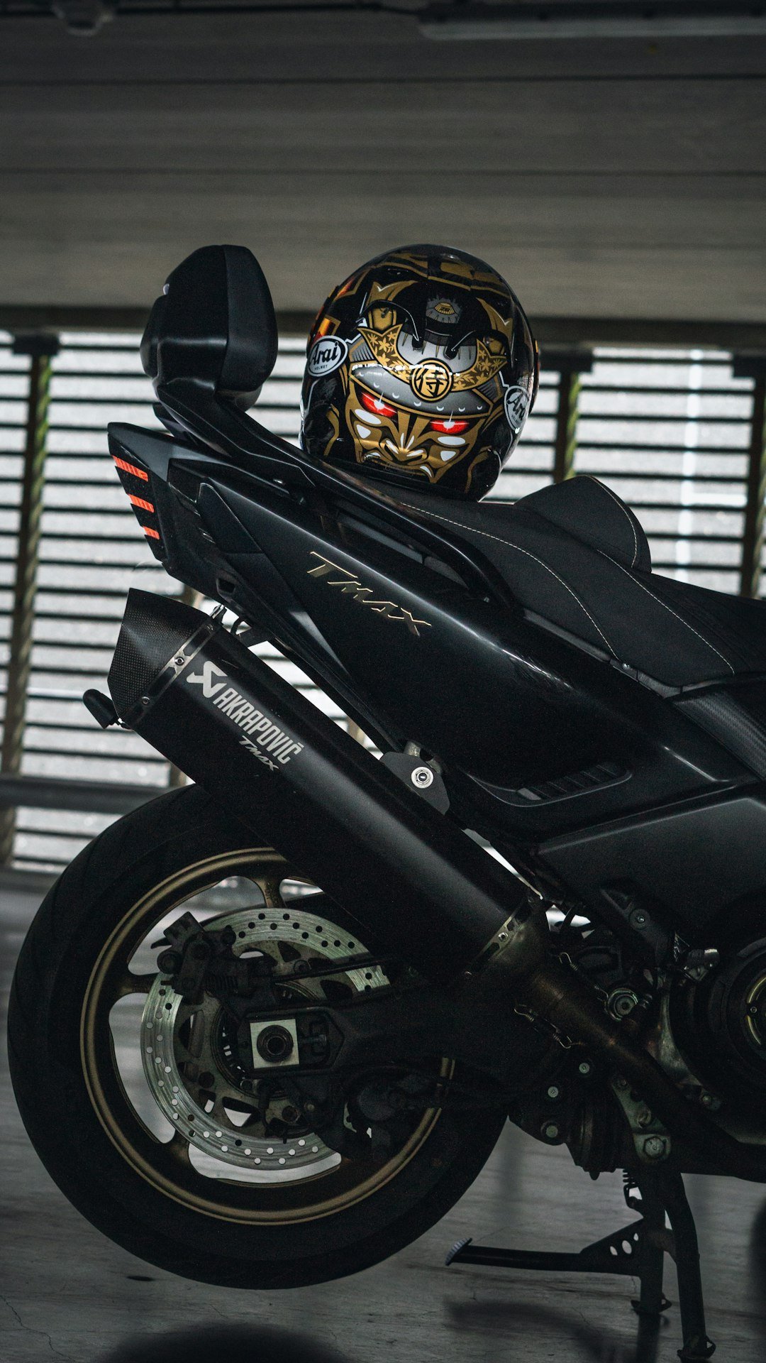 A motorcycle parked in a garage with a helmet on top of it
