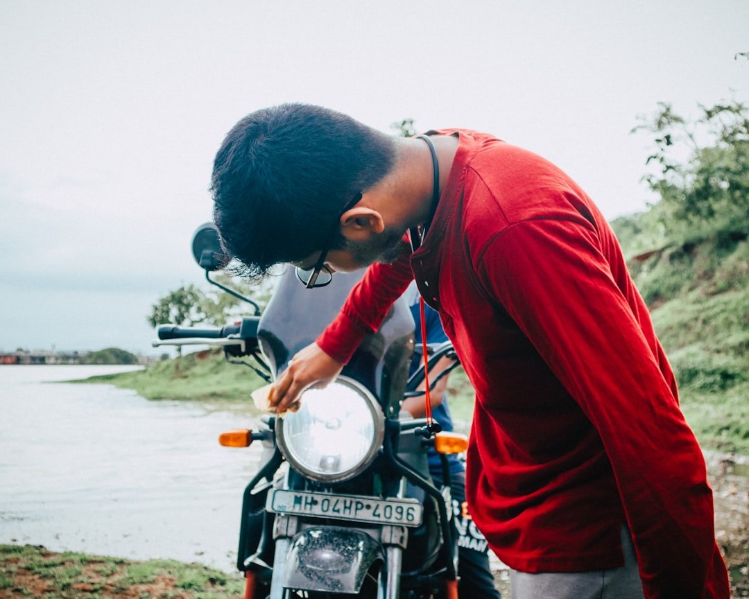 man in red hoodie riding motorcycle during daytime