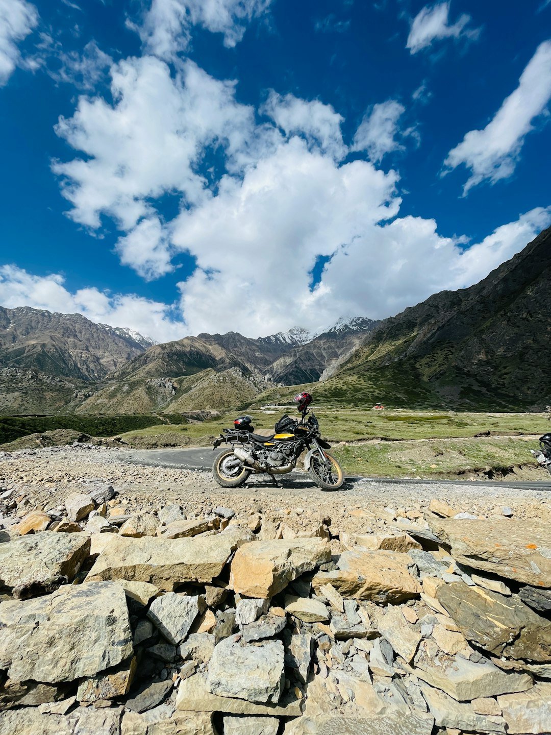 a motorcycle parked on the side of a rocky road
