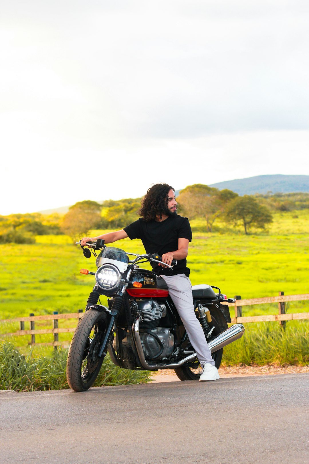 A man sitting on a motorcycle on the side of the road