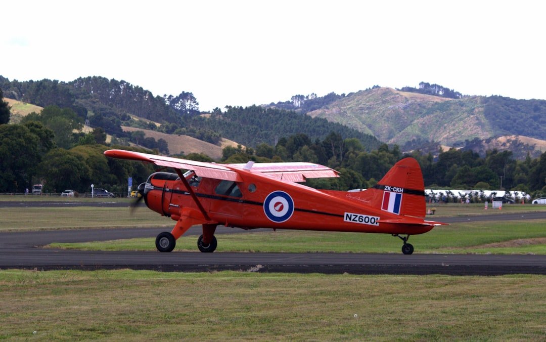 Orange airplane sits on a runway.